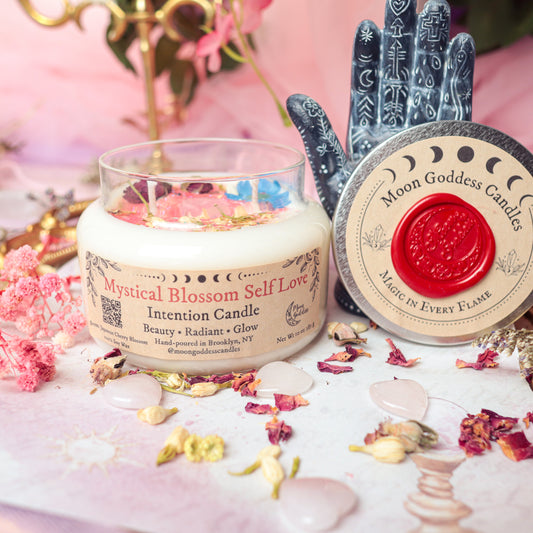 Mystical Blossom Self Love Intention Candle by Moon Goddess Candles, hand-poured in Brooklyn and topped with dried florals, displayed with rose quartz hearts, jasmine buds, and pink aesthetic decor to promote beauty, radiance, and inner glow